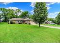 Lovely home with mature landscaping, manicured lawn, and a long driveway at 9002 Walton St, Indianapolis, IN 46231