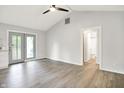Open-concept living room with vaulted ceilings, wood-look floors, and access to a bathroom at 9002 Walton St, Indianapolis, IN 46231