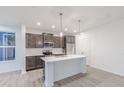 Bright kitchen with stainless appliances, gray cabinets, white counters, and modern lighting at 9136 Anthem Ave, Plainfield, IN 46168