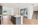 Modern kitchen with an island, stainless steel appliances, pendant lighting, and sliding glass doors at 9160 Anthem Ave, Plainfield, IN 46168