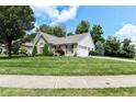 Beautiful home showcasing a well-maintained lawn, mature trees and attached garage at 11692 Seven Oaks Dr, Fishers, IN 46038