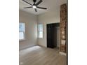 Bedroom featuring light floors, two windows, closet, and exposed brick wall at 1318 Hoyt Ave, Indianapolis, IN 46203