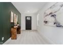 Inviting entryway with light wood floors, black door, neutral decor, and stylish accents at 1318 Hoyt Ave, Indianapolis, IN 46203
