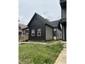 Side view of renovated house featuring black and white siding, new windows and foundation at 1318 Hoyt Ave, Indianapolis, IN 46203