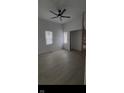 Light-filled living room features modern flooring, new paint, fan, and windows at 1318 Hoyt Ave, Indianapolis, IN 46203