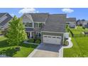 Beautiful two-story home with stone accents, a well-manicured lawn, and an attached two-car garage at 13485 Mancroft Dr, Fishers, IN 46037