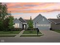 Charming single-Gathering home showcasing its manicured lawn and attached two-car garage at dusk at 14458 Carlow Run, Carmel, IN 46074