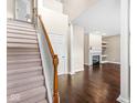 Inviting foyer with staircase, dark wood floors, and a view of the living room with a fireplace at 15421 Bowie Dr, Westfield, IN 46074