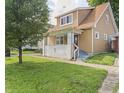 Charming two-story home with a covered front porch and landscaped lawn with mature trees providing shade at 1720 Woodlawn Ave, Indianapolis, IN 46203