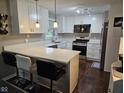 Modern kitchen featuring white cabinets, stainless steel appliances, quartz countertops, and barstool seating at 1733 E 47Th St, Anderson, IN 46013