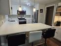 Updated kitchen with white cabinets, stainless steel appliances, quartz countertops, and eat-in bar at 1733 E 47Th St, Anderson, IN 46013