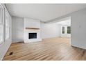 Bright living room featuring light wood floors, white brick fireplace and a large window at 1826 Shorter Dr, Indianapolis, IN 46214