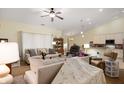 Bright living room featuring neutral tones, a ceiling fan, and an open layout connected to the dining area at 18913 Course View Rd, Noblesville, IN 46060
