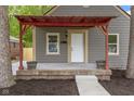 Close-up on the home's front entrance, emphasizing the charming red porch and well-kept landscaping at 2046 N Tibbs Ave, Indianapolis, IN 46222