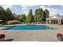 Inviting pool area with an in-ground pool, spa, lounge chairs, and a pool house at 24 Shannon Rd, Zionsville, IN 46077