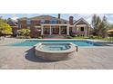 Stunning backyard oasis with a pool, hot tub, and covered patio with white columns at 24 Shannon Rd, Zionsville, IN 46077