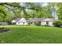 Spacious front yard with mature landscaping, features a well-maintained lawn and inviting facade at 445 W 63Rd St, Indianapolis, IN 46260