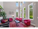 Sun-drenched living room showcasing soaring ceilings, large windows, sleek furnishings, and a decorative area rug at 4691 Pascagoula Run, Greenwood, IN 46143
