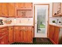 Traditional kitchen with wood cabinets, white countertops, and a door leading to the backyard at 5135 Moller Rd, Indianapolis, IN 46254
