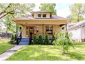 Inviting home featuring a well-manicured lawn, cozy front porch swing, and lovely curb appeal at 517 Bernard Ave, Indianapolis, IN 46208
