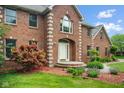A well-maintained two-story brick home with a landscaped front yard and inviting walkway at 5313 Redbird Dr, Columbus, IN 47201