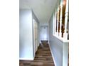 A hallway featuring wood floors and light blue walls, with a staircase on the right at 5760 Tim Tam Ct, Indianapolis, IN 46237