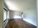 A bright living room with textured wallpaper, wood-look floors, and ample natural light at 5760 Tim Tam Ct, Indianapolis, IN 46237