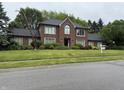 Beautiful brick home with black roof, manicured lawn, and professional landscaping at 6609 N Tuxedo Ln, Indianapolis, IN 46220