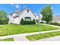 The front of the home has lovely shrubs along the foundation and a manicured lawn at 6610 Royal Oakland Dr, Indianapolis, IN 46236
