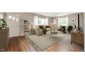 Well lit living room with hardwood floors, a large area rug, and neutral paint to showcase decor at 7482 W Us Highway 40, Indianapolis, IN 46229