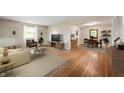Bright, open living room featuring hardwood floors, neutral paint, natural light and an open concept to the dining area at 7482 W Us Highway 40, Indianapolis, IN 46229