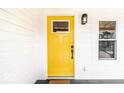 Close-up of a vibrant yellow front door with a classic design and complementing hardware at 918 S State Ave, Indianapolis, IN 46203