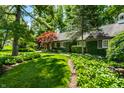 Landscaped front yard features lush gardens and a well-manicured lawn at 9550 Copley Dr, Indianapolis, IN 46260