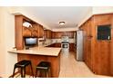 Traditional kitchen featuring wood cabinets, modern appliances, and a breakfast bar with seating at 1010 Lakewood N Dr, Brownsburg, IN 46112