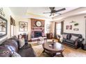 Cozy living room featuring a fireplace, plush sofas, and a ceiling fan at 1010 Lakewood N Dr, Brownsburg, IN 46112
