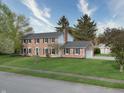 Well-maintained brick house with a two-car garage and a spacious lawn with mature trees at 10245 Briar Creek Ln, Carmel, IN 46033