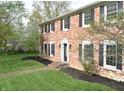 Charming brick home featuring classic black shutters, a tidy yard, and lush landscaping at 10245 Briar Creek Ln, Carmel, IN 46033