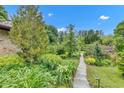 Beautifully landscaped backyard featuring a stone path and mature greenery at 10444 N State Road 9, Fountaintown, IN 46130