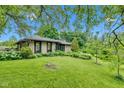 Picturesque home showcasing stone facade, mature trees and verdant lawn at 10444 N State Road 9, Fountaintown, IN 46130