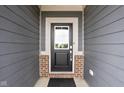 Stylish black front door framed by gray siding and brick accents for a welcoming entrance at 11588 Brooks Farm Blvd, Noblesville, IN 46060