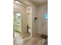 Neutral entryway featuring a gray wood-look floor, and views of a bathroom and front door at 1349 Sunset Blvd, Avon, IN 46123