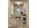 Bright entryway featuring a gray wood-look floor, front door, and console table at 1349 Sunset Blvd, Avon, IN 46123