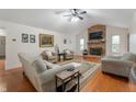 Cozy living room with a fireplace, ceiling fan, and hardwood floors at 2027 Round Barn Ct, Anderson, IN 46017