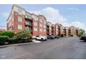A brick condo building featuring multiple balconies and ample parking space at 20971 Shoreline Ct # 201, Noblesville, IN 46062