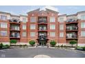 A brick condo building featuring multiple balconies and front entrance access at 20971 Shoreline Ct # 201, Noblesville, IN 46062