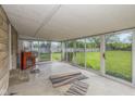 Bright sunroom with walls of windows offering serene backyard views and concrete flooring at 2445 S Bolton Ave, Indianapolis, IN 46203