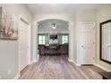 Inviting foyer featuring wood flooring, neutral paint, and an archway leading to the living room at 2717 W Long Meadow Ln, Muncie, IN 47304