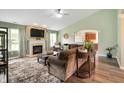 Cozy living room with a fireplace, large sectional, and view of the kitchen through an arched doorway at 2717 W Long Meadow Ln, Muncie, IN 47304