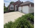 Charming single Gathering home featuring a 2 car garage, landscaped front yard, and red exterior at 3403 Island Way, Indianapolis, IN 46214