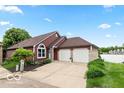 Inviting red-sided house with a two-car garage and well-maintained landscaping near a picturesque lake at 3403 Island Way, Indianapolis, IN 46214